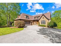 Beautiful two-story home showcasing a well-manicured lawn, a stone facade, and a circular driveway at 401 Yorkfield Dr, Shelby, NC 28150