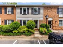 Charming townhome featuring a brick and siding exterior with well-maintained landscaping and black shutters at 4605 Hedgemore Dr # I, Charlotte, NC 28209