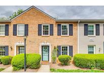 Charming brick townhouse with navy shutters, tidy landscaping and a pop of color from the front door at 4607 Hedgemore Dr # H, Charlotte, NC 28209