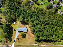 Expansive aerial view of a charming home nestled among mature trees and lush landscaping at 5303 Rogers Rd, Monroe, NC 28110