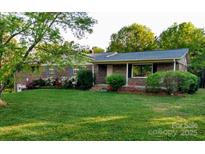 Charming brick home with well-maintained landscaping and inviting front porch at 5303 Rogers Rd, Monroe, NC 28110