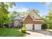 Charming two-story brick home with attached two-car garage and manicured lawn at 7815 Scottsburg Ct, Mint Hill, NC 28227