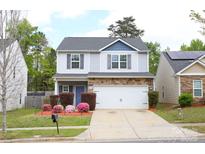 Charming two-story home with stone accents, a two-car garage, and a well-maintained front yard at 8820 First Run Ct, Charlotte, NC 28215