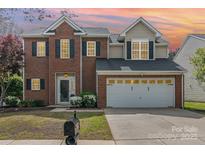 Charming two-story brick home featuring a two-car garage and professionally landscaped front yard at 9803 Forest Run Ln, Charlotte, NC 28277