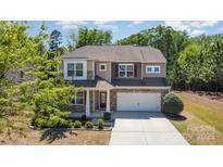 Inviting two-story home with a manicured lawn, stone accents, and a two-car garage at 1176 Shiloh Bend Trl, Fort Mill, SC 29715