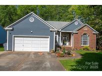Charming single-story home with blue siding, brick accents, and a well-manicured front yard at 12435 Mallard Dr, Charlotte, NC 28269