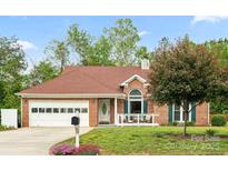 Charming brick home with a well-manicured lawn, inviting front porch and two car garage at 1280 Willowbreeze Sw Ct, Concord, NC 28025