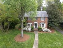 Charming brick home with beautiful landscaping and walkway leading to the front door at 1943 S Wendover Rd, Charlotte, NC 28211