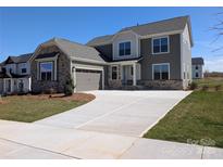 Beautiful two-story home with a stone facade, attached garage, and a long driveway at 2084 Fordhill St, Rock Hill, SC 29732