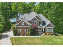 Beautiful two-story home with stone accents and a well-manicured lawn, nestled amongst mature trees at 2501 Mt Isle Harbor Dr, Charlotte, NC 28214