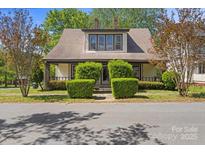 Charming home featuring a dormer window and inviting front porch, nestled amongst manicured trees at 510 S Carolina Ave, Spencer, NC 28159