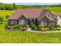 Charming brick home featuring a lush, landscaped front yard with inviting curb appeal at 514 Clover Leaf Rd, Marshville, NC 28103