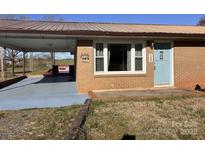Cozy brick home with covered carport and inviting light blue front door at 7527 Old Shelby Rd, Vale, NC 28168