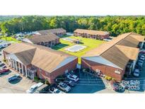 A beautiful aerial view of a brick apartment complex with a pool and well-maintained landscaping, creating a peaceful atmosphere at 103 Carriage House Dr, Kannapolis, NC 28081