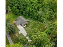 Aerial view of a charming single-Gathering home nestled among lush green trees with a long driveway and large lot at 10340 Williams Rd, Mint Hill, NC 28227
