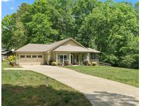 Charming single-story home featuring a two-car garage, screened porch, and a well-manicured lawn at 10340 Williams Rd, Mint Hill, NC 28227