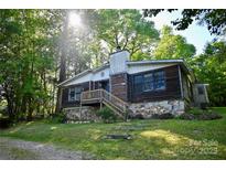 Charming home featuring a stone foundation and wooden siding, nestled in a lush, green environment at 1042 Jackson Rd, Fort Lawn, SC 29714