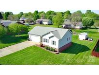 Well-maintained single-story home with a gray roof, complemented by lush greenery and a spacious front yard at 123 Cross Creek Dr, Statesville, NC 28625