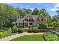 Stately brick home with manicured lawn and garden features lush landscaping and a grand entrance at 17040 Jetton Rd, Cornelius, NC 28031