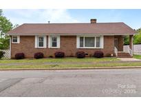 Charming brick home featuring white trim, complementing the landscape at 182 Ryan St, Salisbury, NC 28144