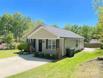Charming single-story home featuring a well-manicured lawn and a classic design with a welcoming front porch at 379 Maiden Sw Ln, Concord, NC 28025