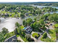 Stunning aerial view of a lakefront home with a pool, lush landscaping, and private dock at 4039 5Th Nw St, Hickory, NC 28601