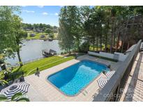 Beautiful pool overlooking the lake with an umbrella table and lounge chairs for relaxation at 4039 5Th Nw St, Hickory, NC 28601