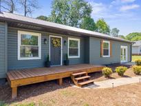 Charming home featuring a wood deck, a decorative front door, and lush landscaping at 4115 Conley St, Newton, NC 28658