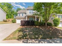 Charming two-story home with a well-manicured lawn, two-car garage, and inviting front porch at 4861 Samuel Pinckney Dr, Belmont, NC 28012