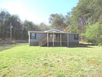 Charming home featuring a covered front porch and surrounded by lush greenery at 5180 Macedonia Church Rd, Vale, NC 28168