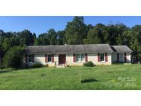 Charming brick home featuring red shutters, complemented by a lush, green lawn at 629 Belmorrow Dr, Charlotte, NC 28214