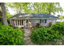 Charming brick home with mature landscaping, a stone walkway, and a cozy, inviting entrance at 7851 Green Cove Ct, Denver, NC 28037