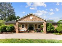 Charming brick home features a cozy porch with swing and manicured landscaping at 11 Secrest Ext, Belmont, NC 28012