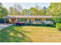 Charming brick home featuring blue shutters and colorful landscaping in the front yard at 113 Princess Ln, Dallas, NC 28034