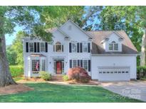 Beautiful two-story white home featuring manicured lawn, brick accents, and attached two-car garage at 1202 Foxfield Rd, Waxhaw, NC 28173