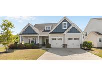 Charming two-story home featuring blue and gray siding, a two-car garage, and a well-manicured front yard at 2704 Watergarden St, York, SC 29745
