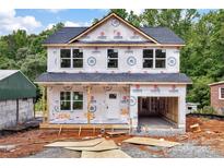 New construction home featuring an attached garage, covered porch, and unfinished landscaping at 530 Gantt St, Mooresville, NC 28115
