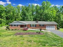 Charming one-story brick home featuring a well-manicured lawn, attached garage, and inviting front porch at 5938 Mundy Rd, Denver, NC 28037