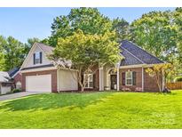 Charming brick home featuring a well-manicured lawn and beautiful landscaping at 6002 Sentinel Dr, Indian Trail, NC 28079