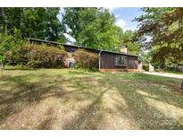 Charming home featuring dark wood siding, large front yard, and well-maintained landscaping at 846 Gist Rd, Rock Hill, SC 29732