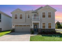 Inviting two-story home with a well-manicured lawn and a charming covered front porch at 9102 Buckley Ct, Charlotte, NC 28269