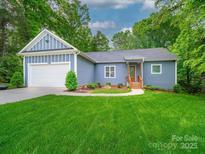 Charming single-story home featuring an attached garage and manicured lawn at 11104 Pine Grove Ave, Mint Hill, NC 28227