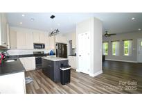 Bright kitchen featuring stainless appliances, a large island, and modern finishes with hardwood style floors at 129 Devon Dr, Heath Springs, SC 29058