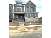 Charming two-story home featuring gray siding, white brick accents, and a welcoming blue front door at 19044 Newburg Hill Rd, Davidson, NC 28036