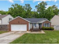 Charming single-story home with brick accents, a two-car garage, and a cozy front porch with rocking chairs at 3022 Willamette Valley Dr, Charlotte, NC 28215