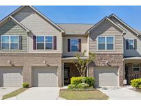 Townhome exterior with brick accents, gray siding, and attached garages at 4011 Black Walnut Way, Indian Land, SC 29707
