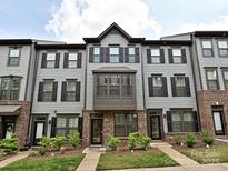 Charming townhome with gray siding, black shutters, brick accents, and well-manicured landscaping at 417 Tristram Ln, Charlotte, NC 28205