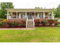 Charming brick home featuring a large porch with white columns and lush red rose bushes at 5840 Shirley Rd, Fort Lawn, SC 29714