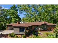 Expansive brick home featuring a covered parking area and plentiful trees at 916 E Park Dr, Lincolnton, NC 28092