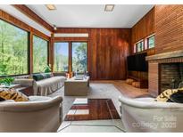 Inviting living room featuring a fireplace, wood paneling, and large windows with natural light at 916 E Park Dr, Lincolnton, NC 28092